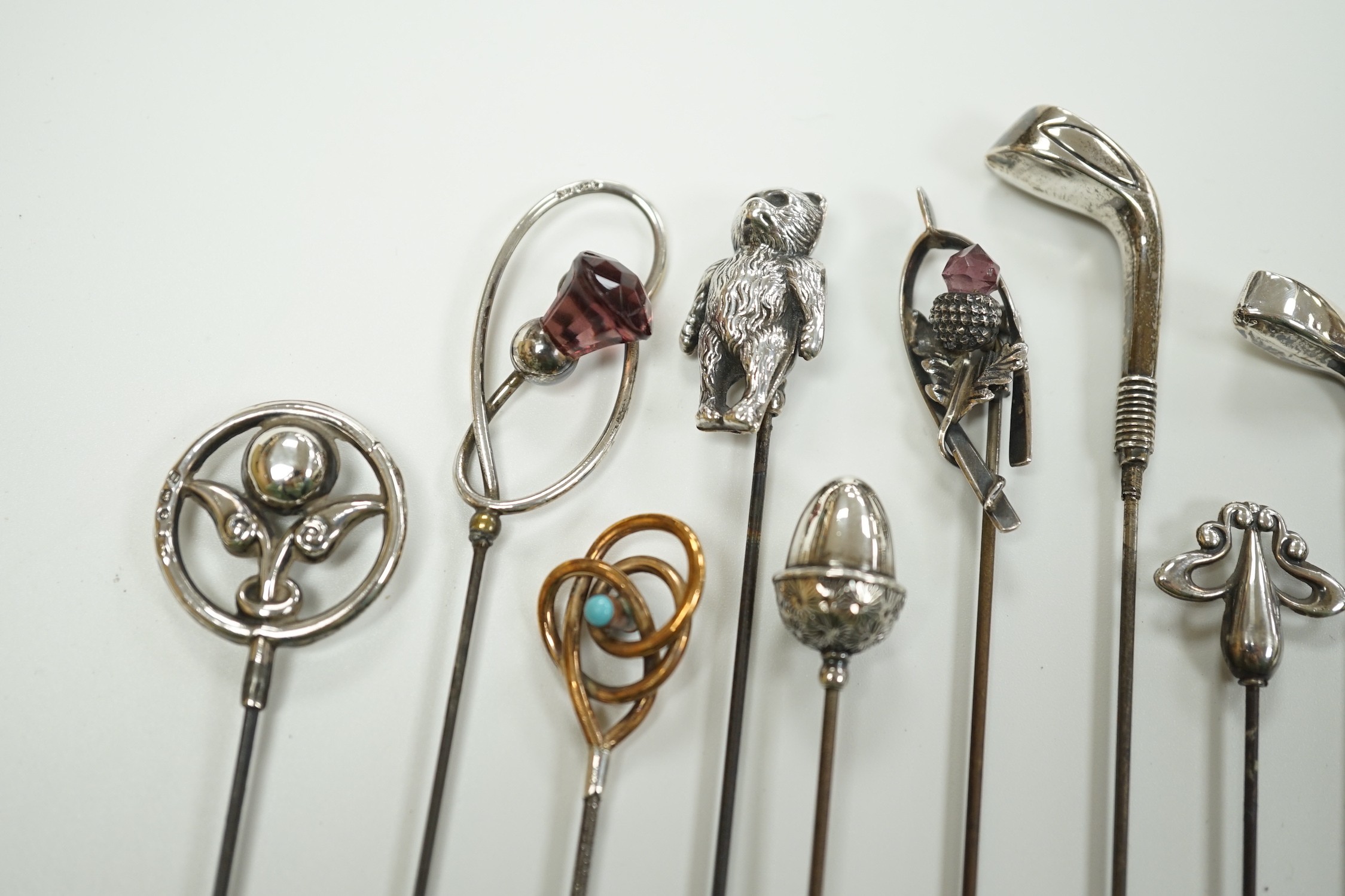 A collection of thirteen assorted early 20th century and later white or yellow metal hat pins, including four by Charles Horner including teddy bear and two silver golf club, longest 31.5cm.